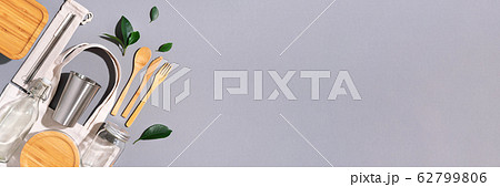 Sustainable lifestyle. Zero waste, plastic free shopping concept. Cotton bags, glass jar, bottle, metal cup, straws for drinking, bamboo cutlery and boxes on gray background. Banner Sustainable lifestyle. Zero waste, plastic free shopping concept. Cotton bags, glass jar, bottle, metal cup, straws for drinking, bamboo cutlery and boxes on gray background. Banner 62799806