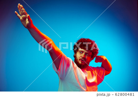 Caucasian man's portrait isolated on blue studio background in neon light Caucasian man's portrait isolated on blue studio background in neon light 62800481