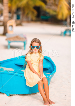 Adorable little girl on boat on white beach 62800701