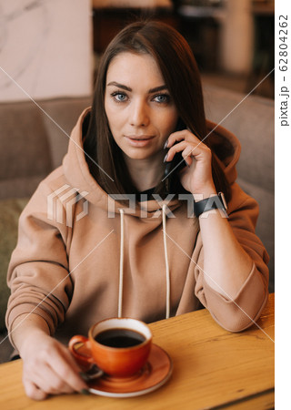 Middle shot portrait of young woman in casual clothes talking on the phone Middle shot portrait of young woman in casual clothes talking on the phone 62804262