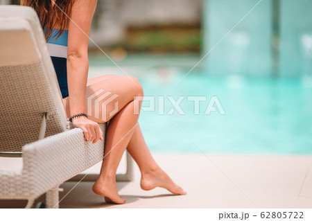 Woman sunbathing on a lounger at tropical resort 62805722