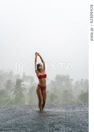 Cheerful Caucasian female vacationer greeting the summer rain 62806426