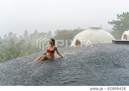 Relaxed tanned Caucasian girl meditating in rainy weather 62806428