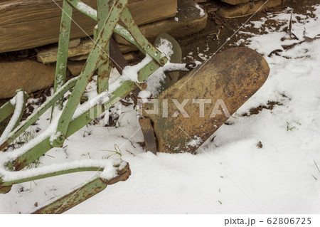 Old rusty plough in snow and wooden cabin Old rusty plough in snow and wooden cabin 62806725