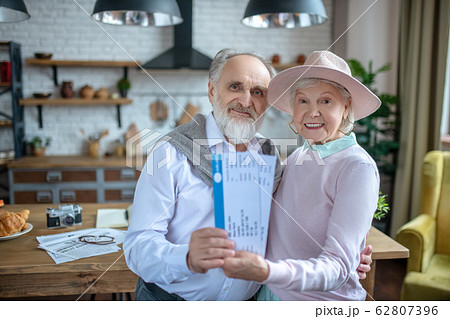Smiling elderly couple preparing tickets for their flight 62807396