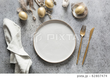 Elegant easter table setting with golden eggs 62807474