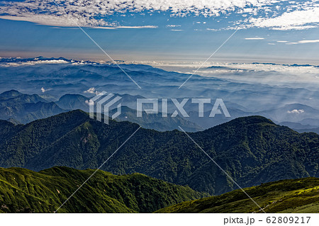 飯豊山から見る山形市方面の山並みと光芒の写真素材