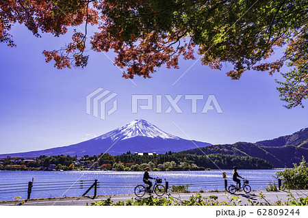 (山梨県)紅葉の河口湖・湖畔サイクリングを楽しむ人達と富士山 (山梨県)紅葉の河口湖・湖畔サイクリングを楽しむ人達と富士山 62809244