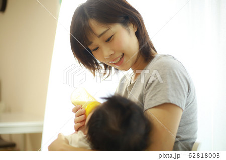 赤ちゃんにミルクを与える母親 赤ちゃんにミルクを与える母親 62818003