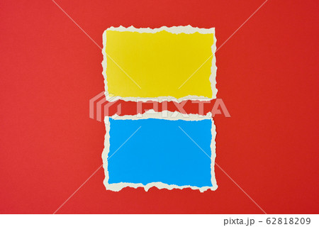 Two ripped paper torn edge sheets on a red 62818209