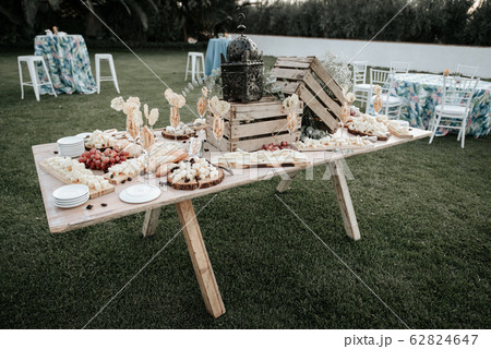 Cheese table of Emmental, Camembert, Parmesan, blue cheese closeup, with bread sticks and grapes on wooden table 62824647