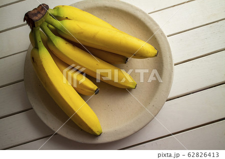 陶器皿のバナナ一房 a bunch of bananas on a ceramic plate 62826413