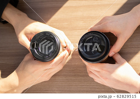コーヒーの紙カップを持った2人の手 コーヒーの紙カップを持った2人の手 62829515