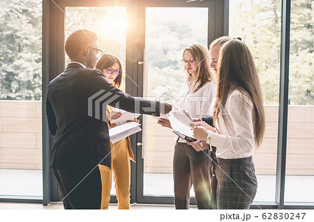 Six young business people analyze the results and discuss them. Group of business people collaborating on project in office 62830247