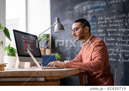 It-manager sitting in front of laptop in office and analyzing coded information 62830719