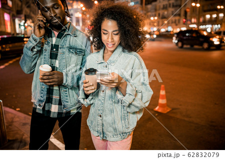 Pretty smiling woman reading messages on the phone in the city Pretty smiling woman reading messages on the phone in the city 62832079