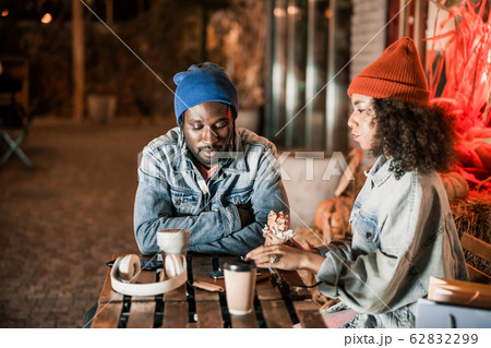 Young couple resting in street cafe with hot drink 62832299
