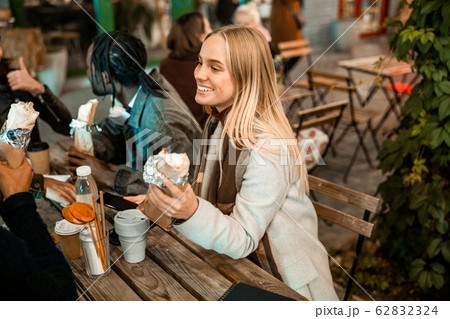 Smiling woman snacking with friends in a cafe...の写真素材 [62832324] - PIXTA