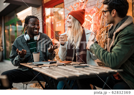 Smiling Afro American guy telling something fun to friends Smiling Afro American guy telling something fun to friends 62832369