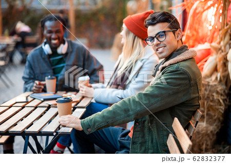 Happy young guy looking at camera in street cafe 62832377