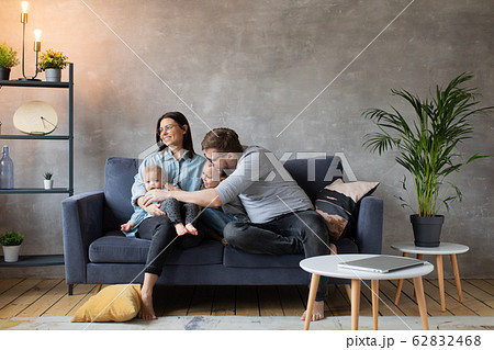 Young Family Playing Together on the Sofa. happy family. home comfort. Young Family Playing Together on the Sofa. happy family. home comfort. 62832468