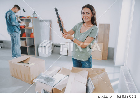 Smiling pretty woman is looking at camera with photo Smiling pretty woman is looking at camera with photo 62833051