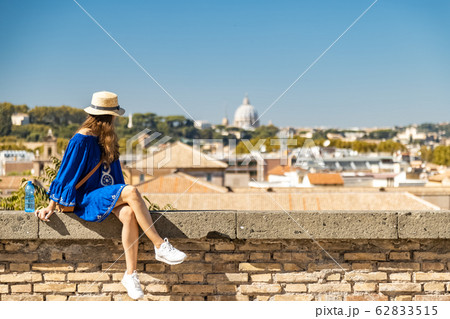 Female watching Rome from the panoramic balcony in the Orange Garden. Woman in blue dress and white straw hat Female watching Rome from the panoramic balcony in the Orange Garden. Woman in blue dress and white straw hat 62833515