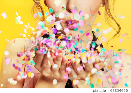 Close up girls lips blowing colorful confetti 62834636