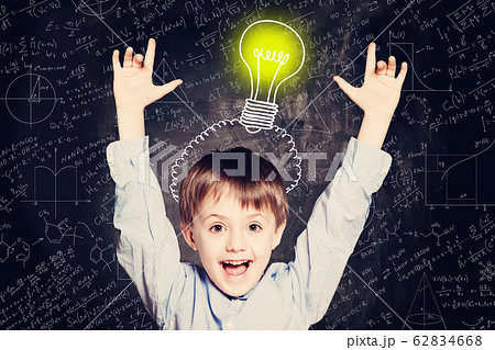 Child boy with hands up and lightbulb.  62834668