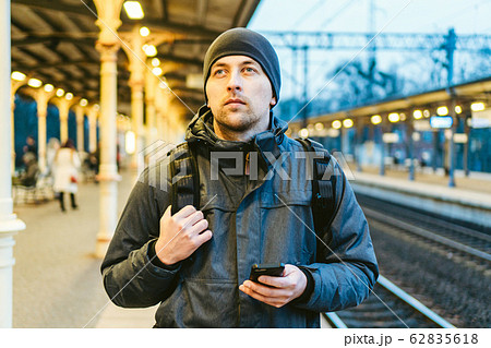 Train Station in Sopot, Poland, Europe. Attractive man waiting at the train station. Thinking about trip, with backpack. Travel photography. tourist with backpack stand on railway station platform 62835618