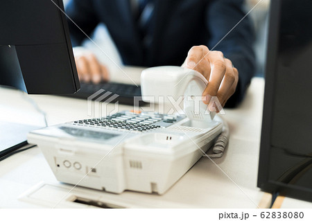若いビジネスマン(電話、オフィス、スーツ、デスクワーク 若いビジネスマン(電話、オフィス、スーツ、デスクワーク 62838080