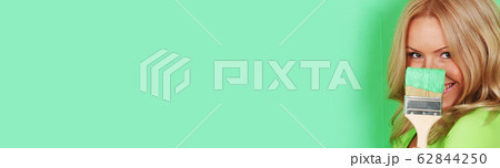 Woman paints wall with brush 62844250