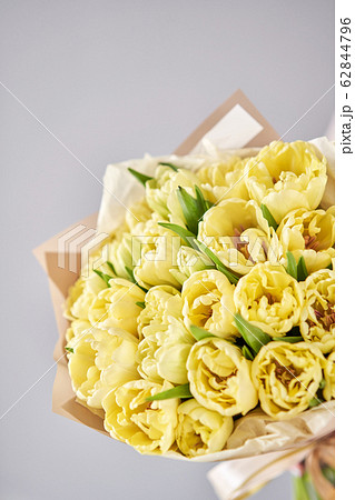 Yellow pastel color tulips in woman hand. Young beautiful woman holding a spring bouquet. Bunch of fresh cut spring flowers in female hands Yellow pastel color tulips in woman hand. Young beautiful woman holding a spring bouquet. Bunch of fresh cut spring flowers in female hands 62844796