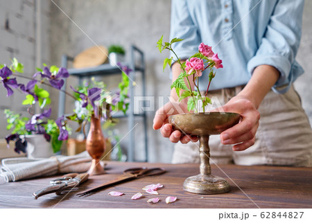 Ikebana in kenzan, scissors and pruner on the table florist. Seasonal summer garden flowers. A young woman florist create flower arrangement. 62844827
