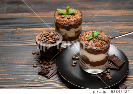 Classic tiramisu dessert in a glass cup on wooden background Classic tiramisu dessert in a glass cup on wooden background 62847424