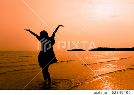 Silhouette happy woman walking on beach Silhouette happy woman walking on beach 62849406