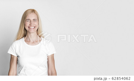 Emotional middle-aged woman laughing at gray studio Emotional middle-aged woman laughing at gray studio 62854062