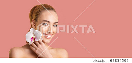 Girl Holding White Orchid Near Face Posing, Pink Background, Panorama 62854592