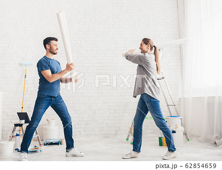 Happy young couple fighting with rollers and smiling each other 62854659