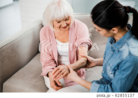 Family doctor holding arm of elderly woman Family doctor holding arm of elderly woman 62855137