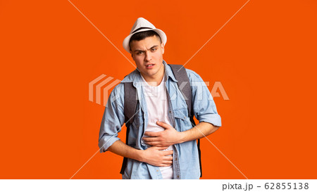Young guy traveler having pain in his stomach Young guy traveler having pain in his stomach 62855138