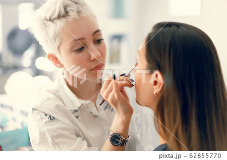 Make-up artist applying bright base color Make-up artist applying bright base color 62855770