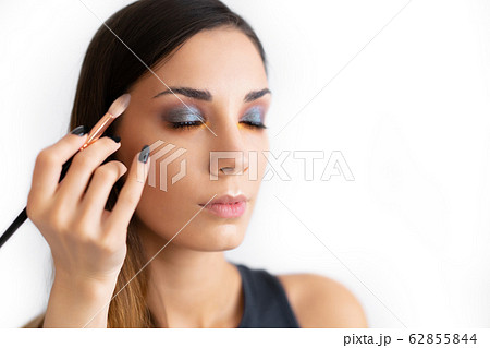 Make-up artist applying bright base color Make-up artist applying bright base color 62855844