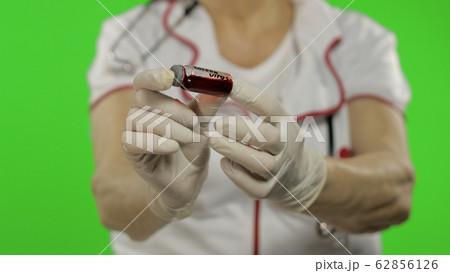 Hands of elderly female doctor. Test tube with analyzes. Coronavirus. Covid-19 Hands of elderly female doctor. Test tube with analyzes. Coronavirus. Covid-19 62856126