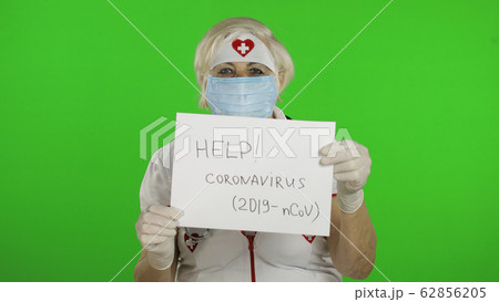 Elderly female doctor in medical mask show page with message. Coronavirus 62856205