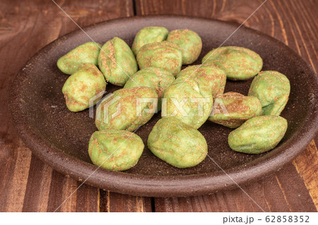 Green wasabi peanut on brown wood Green wasabi peanut on brown wood 62858352