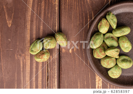Green wasabi peanut on brown wood Green wasabi peanut on brown wood 62858397