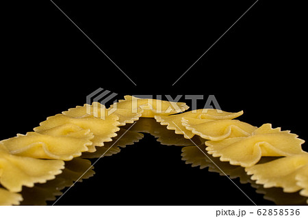 Yellow farfalle pasta isolated on black glass 62858536