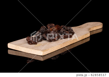 Dried dark raisin isolated on black glass Dried dark raisin isolated on black glass 62858537