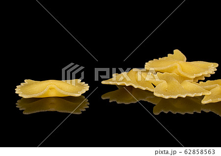 Yellow farfalle pasta isolated on black glass Yellow farfalle pasta isolated on black glass 62858563